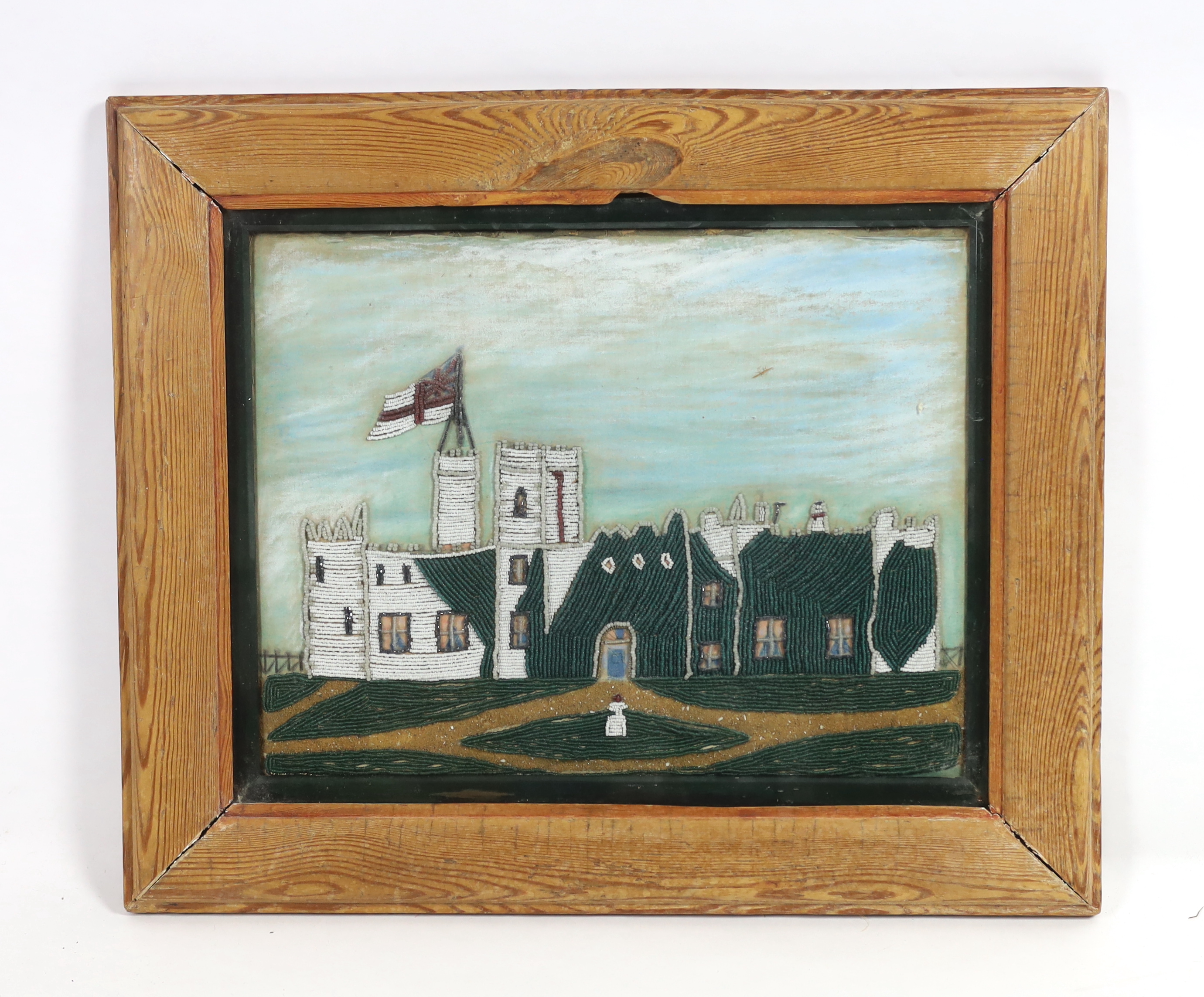 An early Victorian pine framed, Folk Art watercolour, beadwork and sand collage, of a castle with naval pennant, 46cm wide x 35cm high